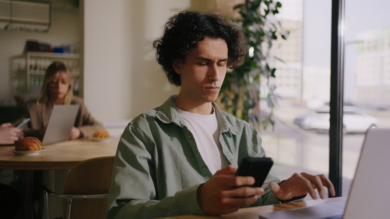 Man looking at his phone at a cafe
