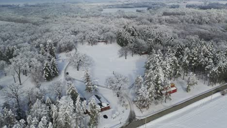 Luftaufnahme-Des-Autos,-Das-Auf-Unbefestigter-Straße-In-Der-Schneewinterwaldlandschaft-Fährt,-Kreisend