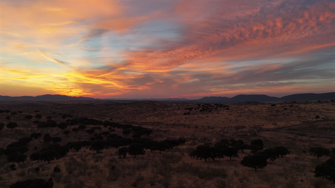 Drone footage of a colorful sunset over dry hills and countryside near Cote, Andalusia, southern Spain