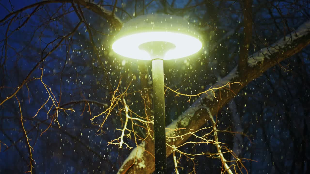Nevicata notturna sotto un lampione luminoso