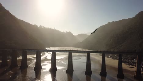Drohnenflug-Der-Alten-Brücke-Bei-Sonnenuntergang-An-Der-Flussmündung
