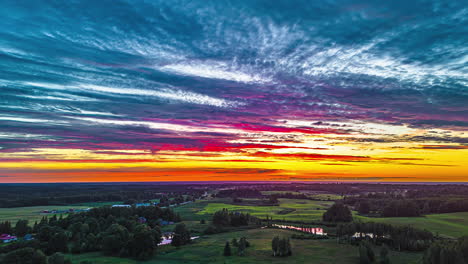 puesta de sol colorida sobre campos de tierras de cultivo y prados - retroceso aéreo hiperlapso