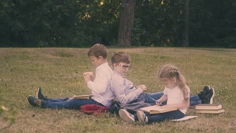 young concentrated pupil reads book sitting near small lady