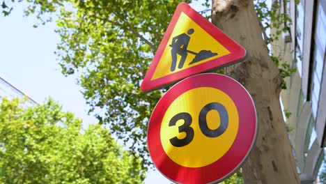 traffic signs alert drivers to upcoming road work and a reduced speed limit of 30 km per hour. a close-up on road safety signage for construction site traffic management
