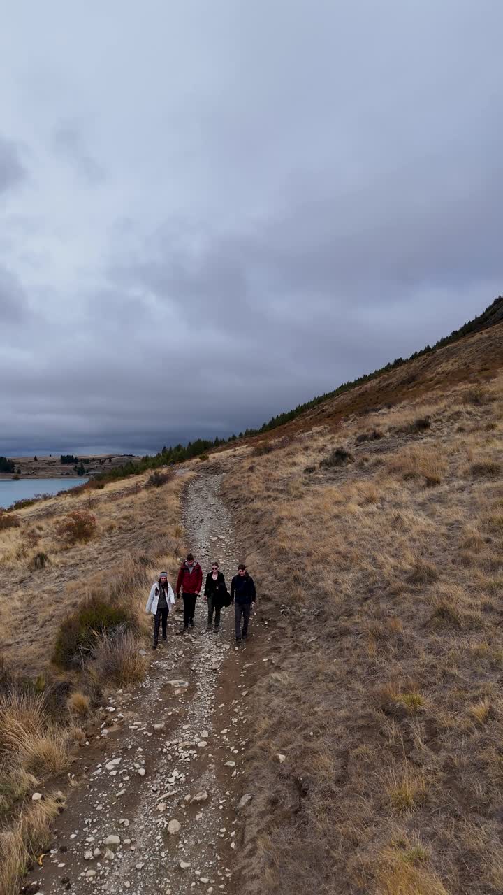 Veduta aerea di amici che fanno escursioni lungo il Lago Tekapo in autunno, Nuova Zelanda. Avventura di viaggio panoramica.