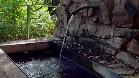 el agua fluye de un grifo de fuente a una fuente