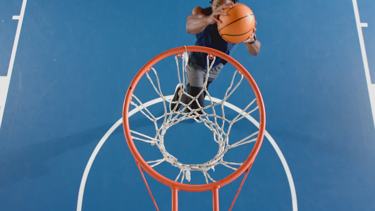 Dunking basketball, woman in action on court, showing athletic skills