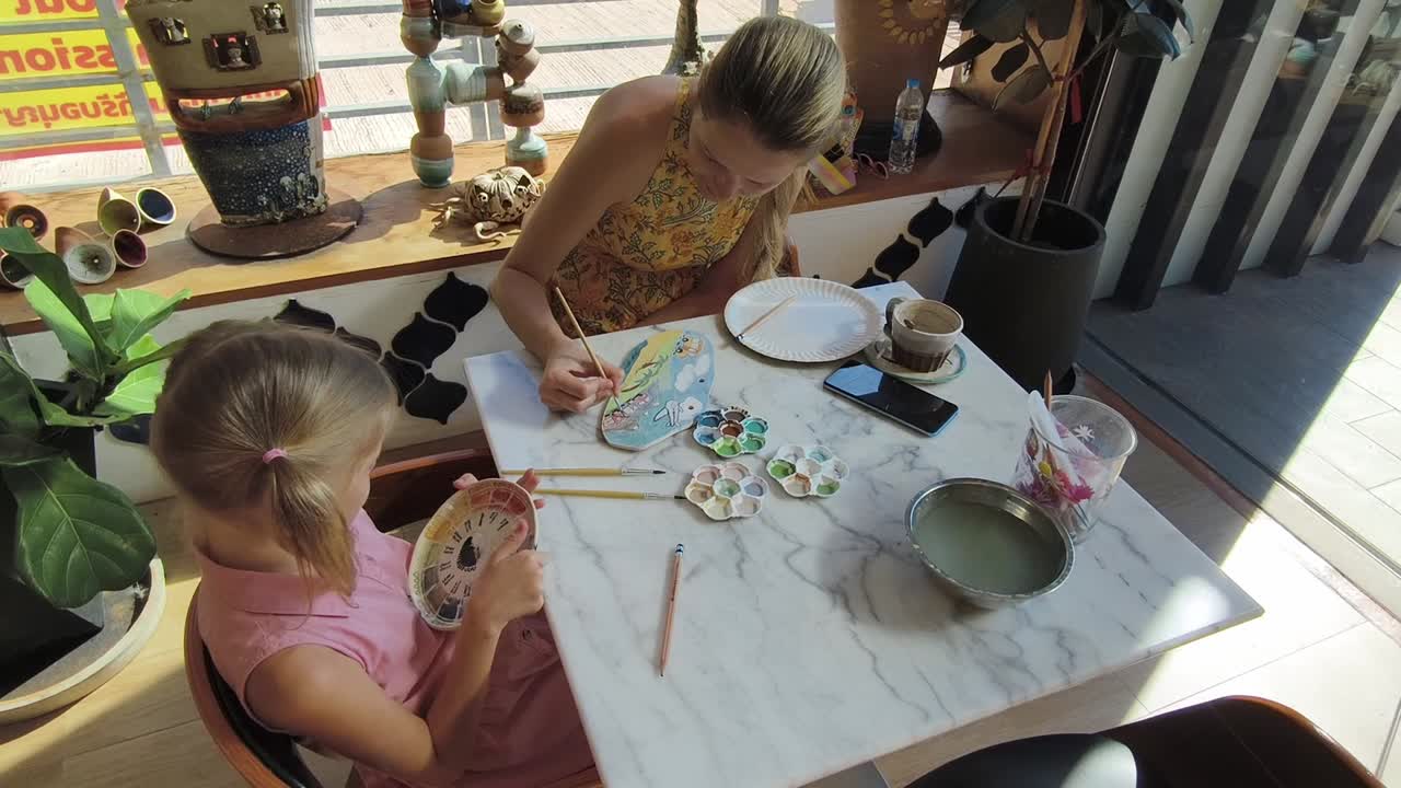어머니 와 딸 이 카페 에서 도자기를 그린다