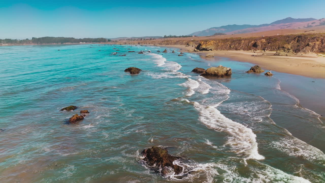 Calming pleasant view of waves moving to the shore. Pacific ocean coastline at Morro Bay, California, USA.