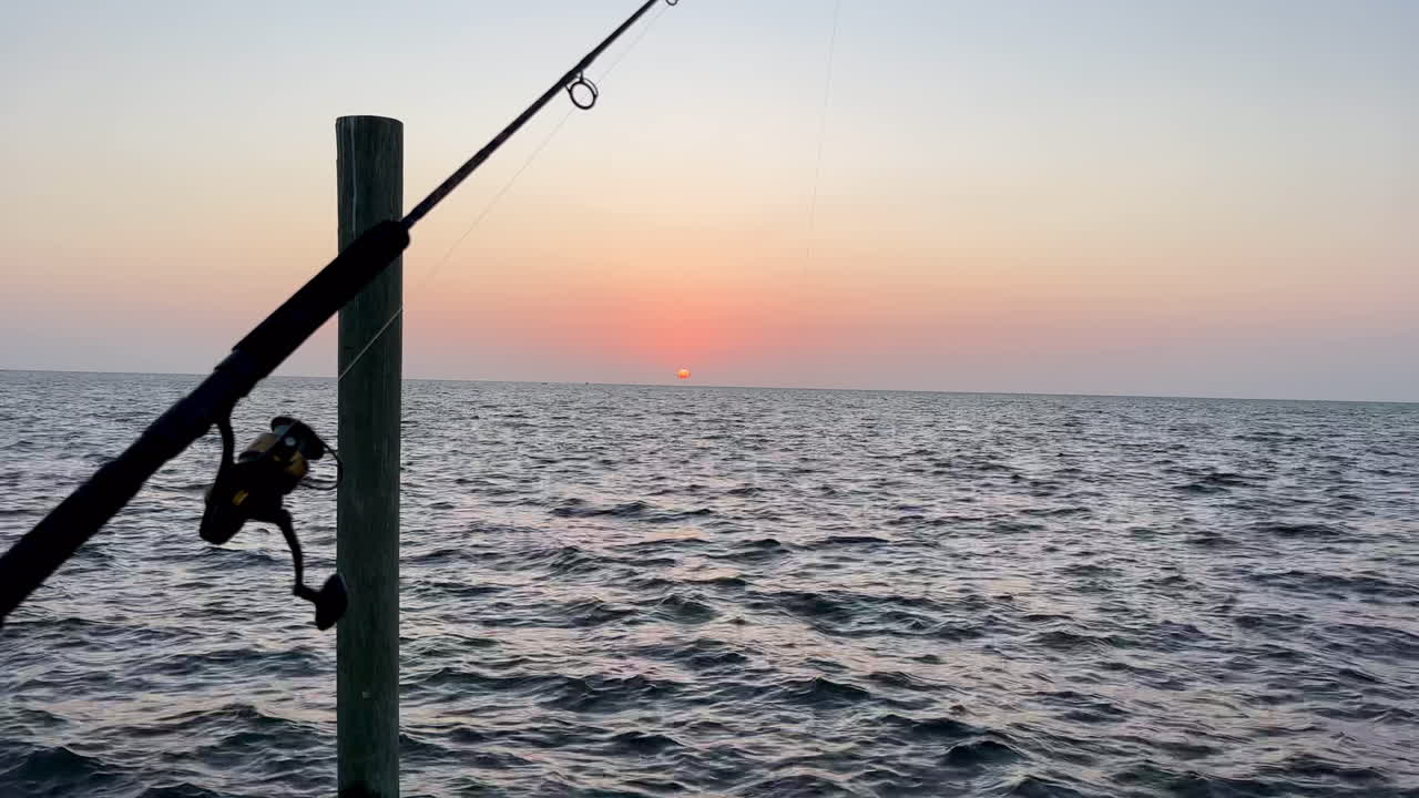 Relaxing golden sunset at dusk and fishing pole, Florida Keys ocean