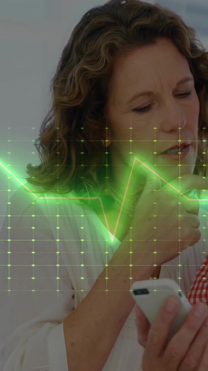 Video verticale: Una forma d'onda ECG verde che pulsa attraverso l'inquadratura sopra una donna che tiene in mano il telefono e controlla la salute.