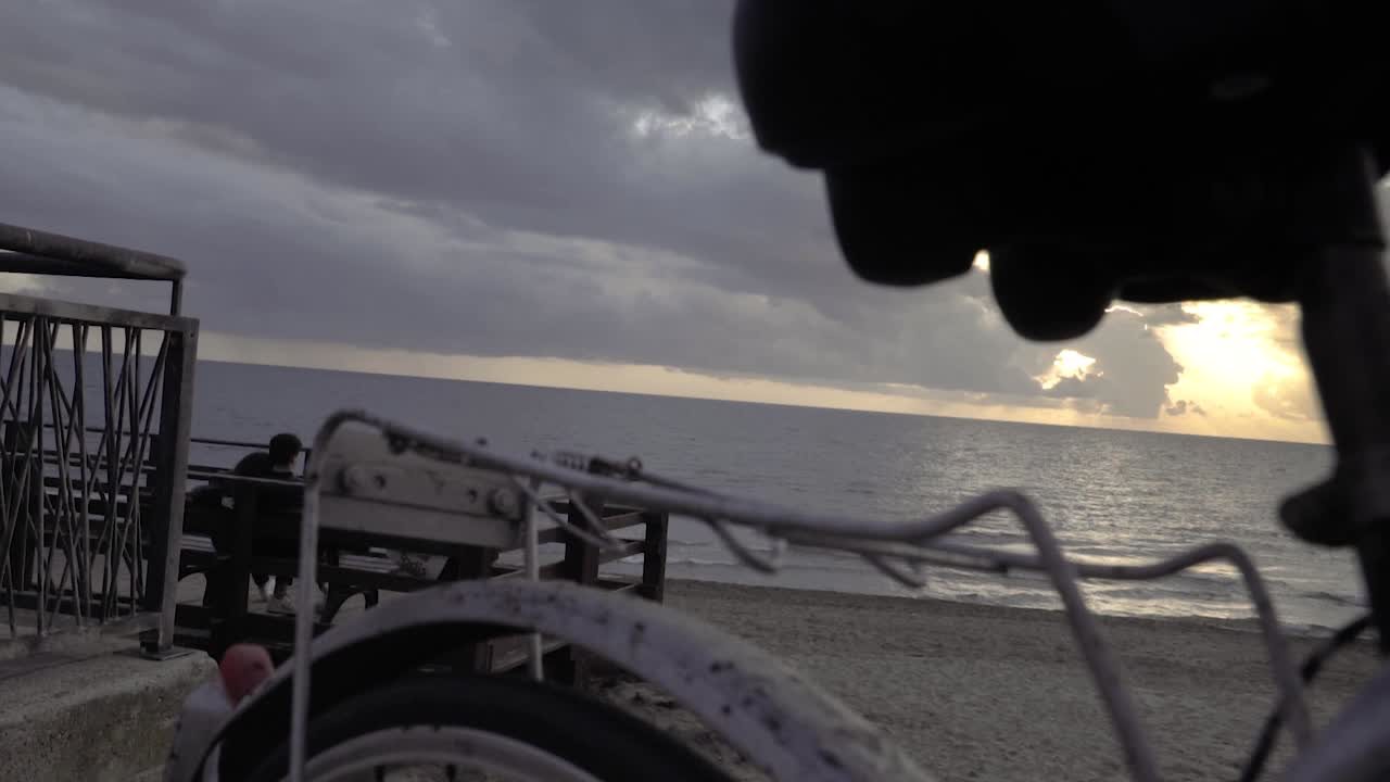 Vintage '80s touring bicycle by the sea with a couple hugging and looking at the sunset SLOW MOTION 120 FPS