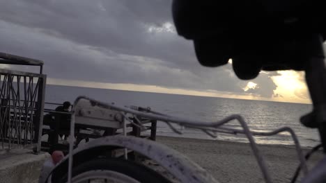 vintage '80s touring bicycle by the sea with a couple hugging and looking at the sunset slow motion 120 fps