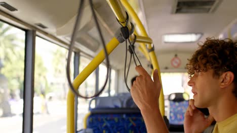 Male-commuter-talking-on-mobile-phone-while-travelling-in-bus-4k