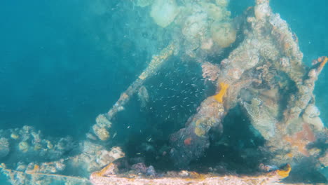 cinematic underwater shot of a ship wreck in clear blue waters in slow motion, 4k, slomo