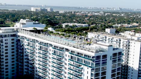 luxurious swimming pool on building rooftop in mid-beach, miami, florida, usa - aerial drone shot