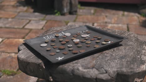 cerca de una bandeja con monedas antiguas etiquetadas "unikat" en una superficie de madera en el mercado de artesanías tradicionales de varaždin