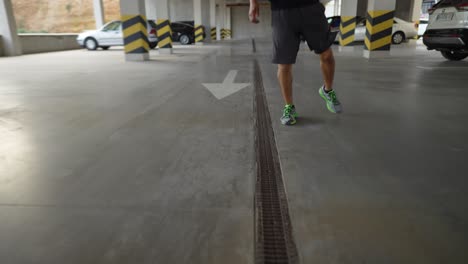 athlete in sportswear warms up on a city parking garage, cropped footage