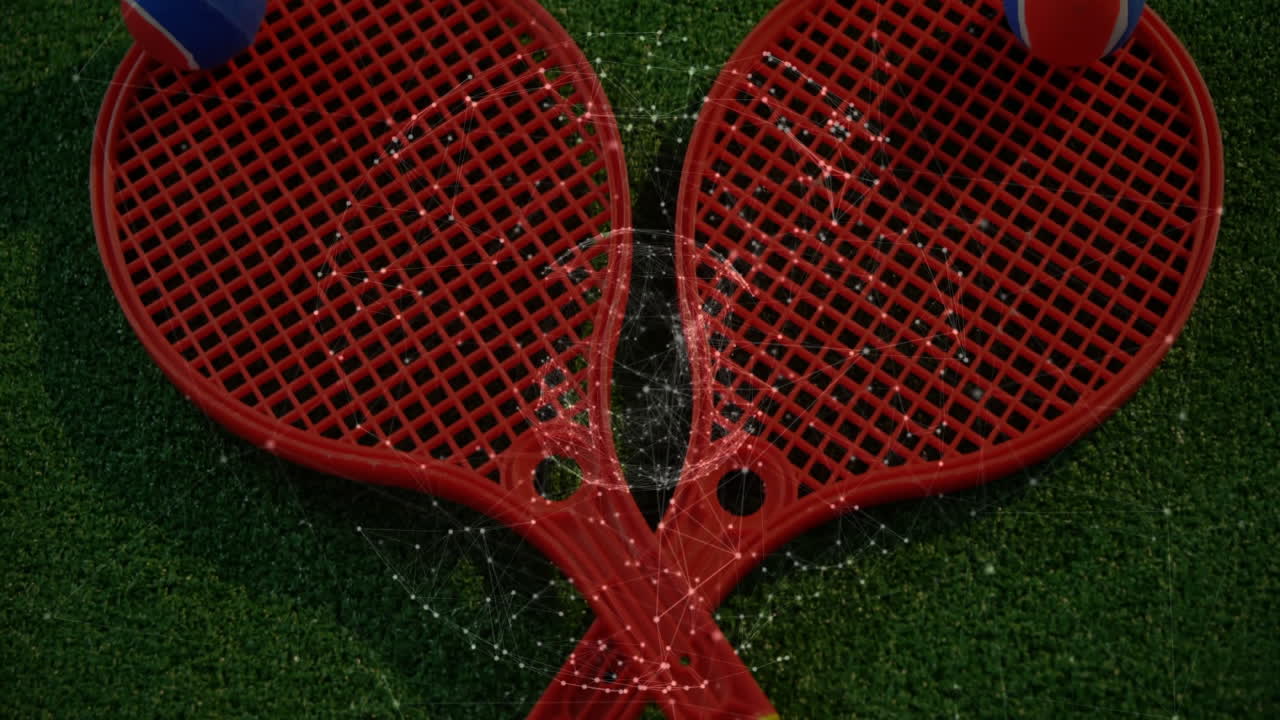 Two red rackets holding balls forming heart shape showing digital overlay, floating over green turf