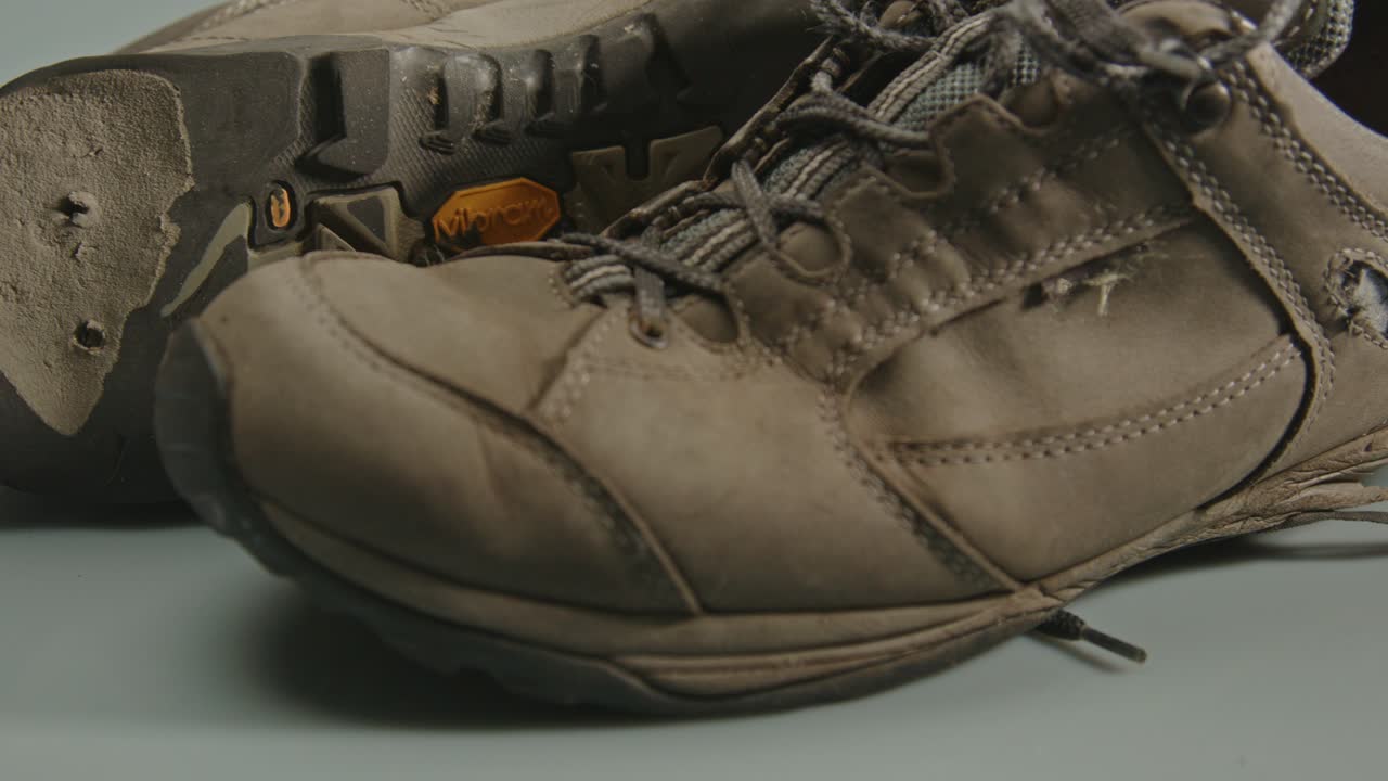 muñeca de dos zapatos de senderismo desgastados con agujeros y tacones rotos