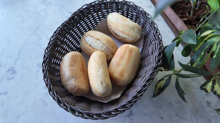 Hand Picking a Fresh Bread Roll from a Wicker Basket