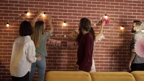 diverse people preparing party indoors, decorating living room