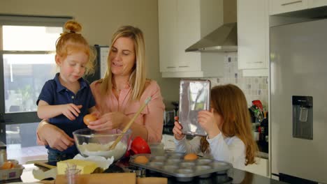 Mother-teaching-their-daughter-to-break-the-egg-while-baking-4k