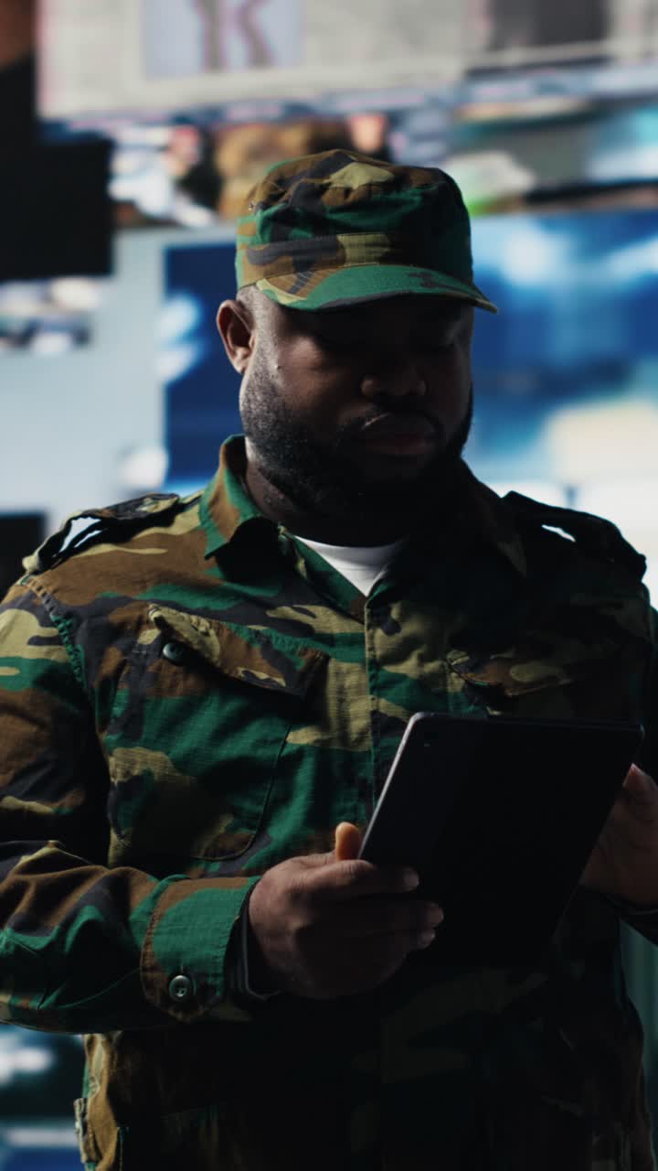 Soldier in Camouflage Uniform Using Digital Tablet in Control Room