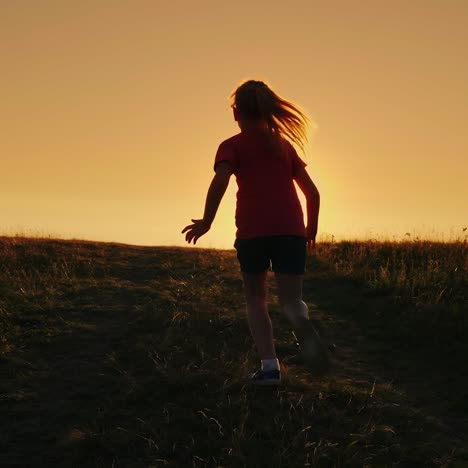 carefree girl runs up the hill on a sunset background