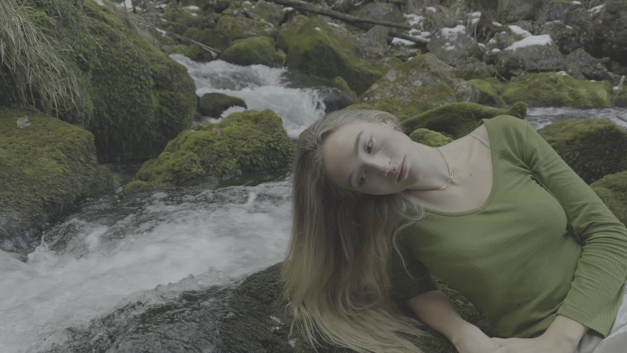 Woman relaxing by a winter stream