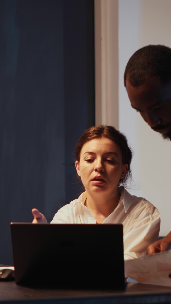 Vertical video: Diverse coworkers doing teamwork in startup office
