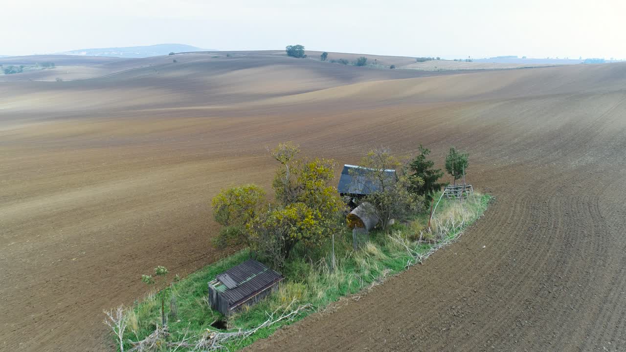 Ripresa aerea che si muove verso una singola casa colonica al centro di un’enorme area coltivata
