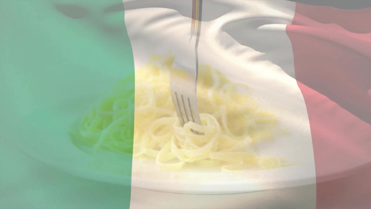 Forchetta che entra e avvolge fili di pasta, sollevandoli per mostrarli su una sovrapposizione di bandiera italiana sventolante.