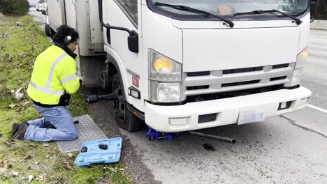 Mexican-man-changing-the-tire-of-a-trailer-stranded-on-the-road