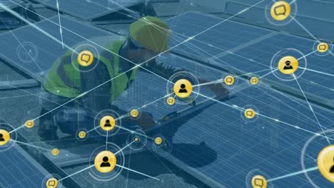 Animation-of-network-of-digital-icons-over-caucasian-male-worker-setting-up-solar-panels-on-the-roof