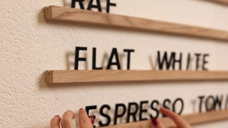 person arranging coffee menu display