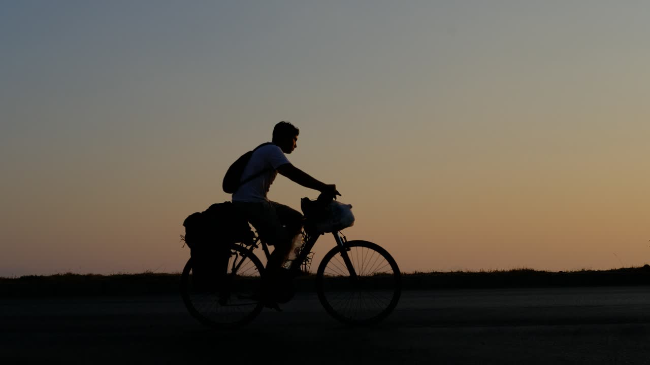 Low angle shot man cycling sunset