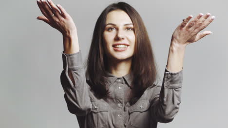 Woman blowing confetti away. Joyful party girl standing and blowing confetti and looking at camera