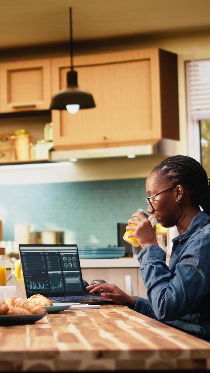 Vertical Video Woman worker takes analytics notes and manages projects on laptop