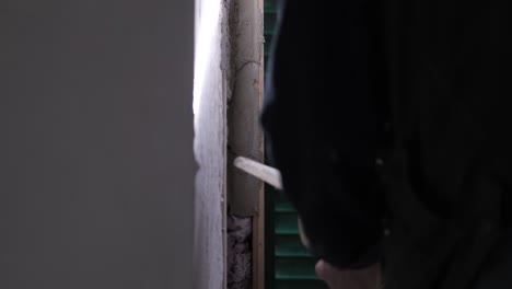 worker applying concrete of a wall near a window