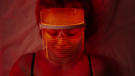 woman using a red light therapy mask for skincare