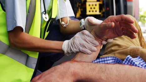 técnico médico de emergencia tomando el pulso de su persona herida