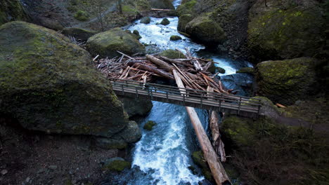 a drone showing a person on a bridge with a river flowing underneath