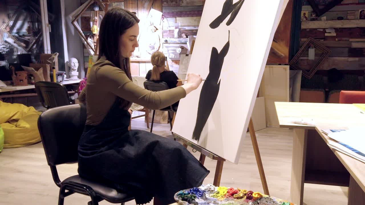 Woman paining on a paper at an art gallery workshop