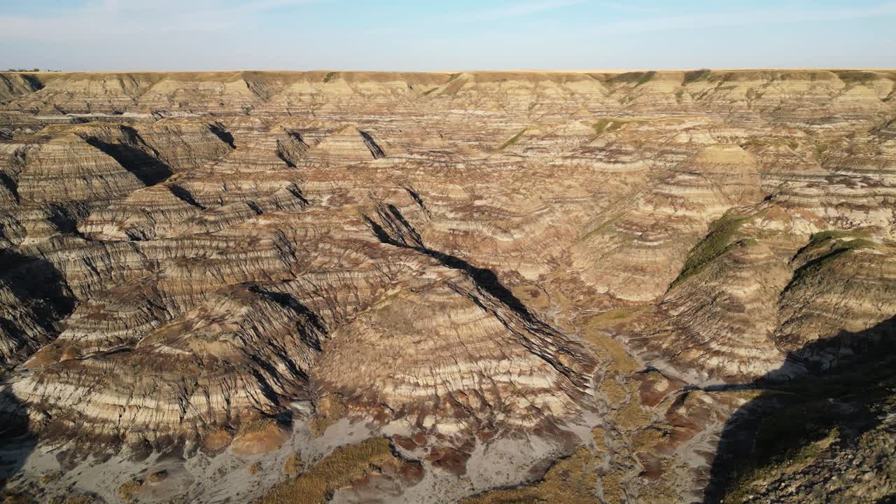 Movimiento aéreo de travelling de un paisaje de cárcavas erosionado en Alberta, Canadá, justo antes del atardecer