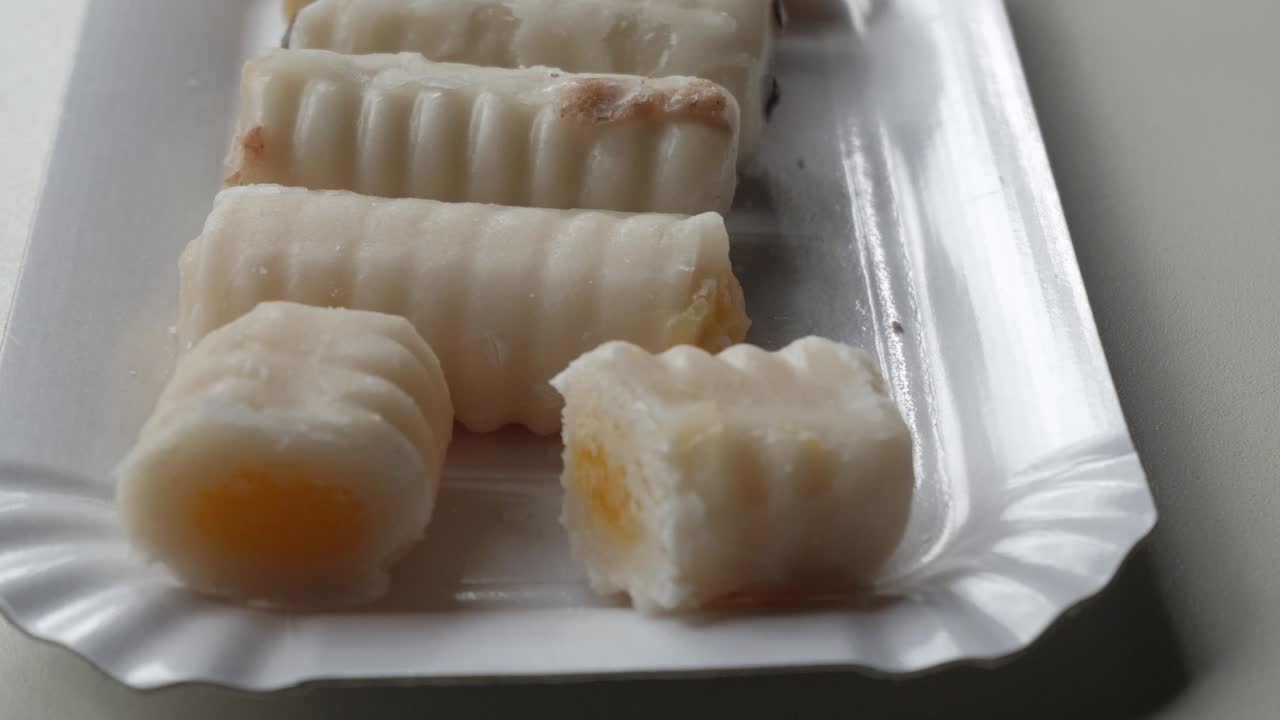 Zoom in delicious spanish sweet, Huesos de Santo (Saint's bones), made out of marzipan, filled different, close up.