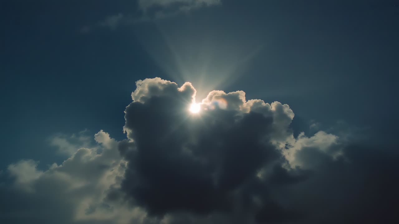 Drifting cloud revealing sun disc in open sky, intensifying sun rays shining through gaps