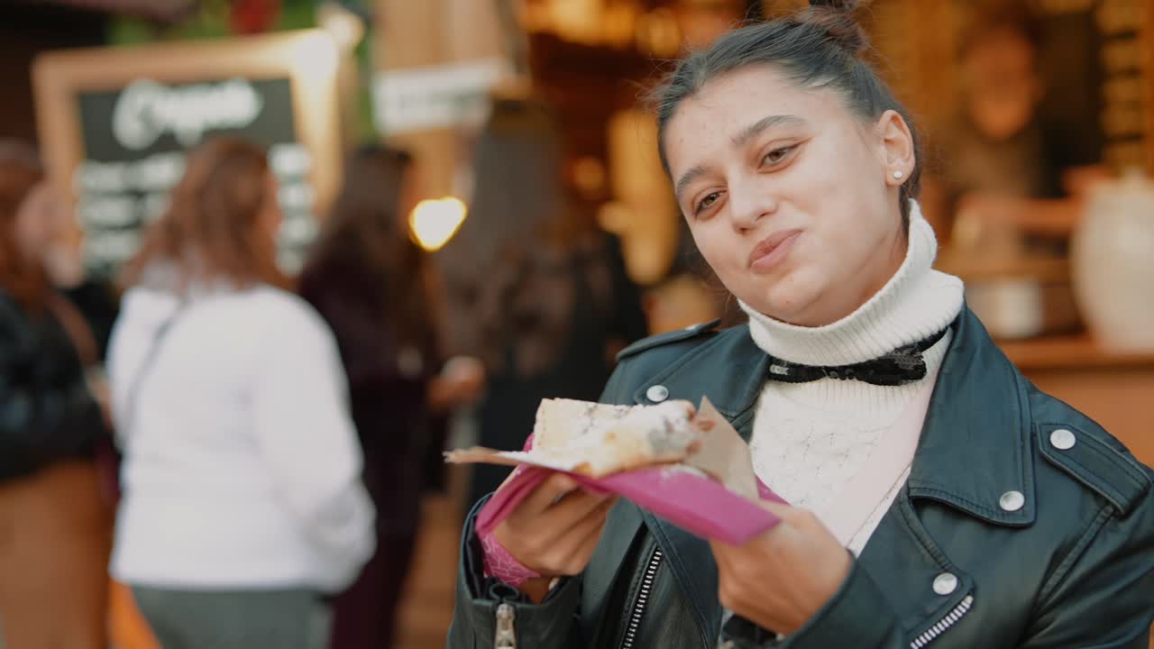 Donna che mangia una crêpe al mercato