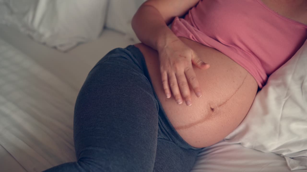 Happy pregnant woman and expecting baby at home.