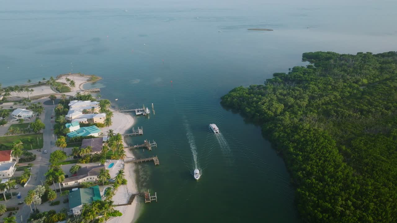 barcos que se mueven a través del canal de la playa de sombrero con casas frente al mar en florida keys